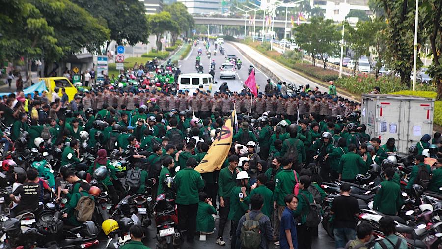Mahasiswa yang akan melakukan aksi unjuk rasa tertahan blokade polisi di Jalan Jend. Sudirman, Jakarta, Senin (15/6/2026). (Bloomberg Technoz/Andrean)