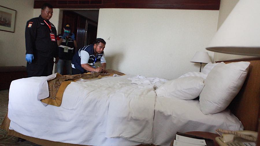 Petugas terlihat mencatat aset yang terdapat di dalam kamar hotel. (Bloomberg Technoz/Andrean Kristianto)