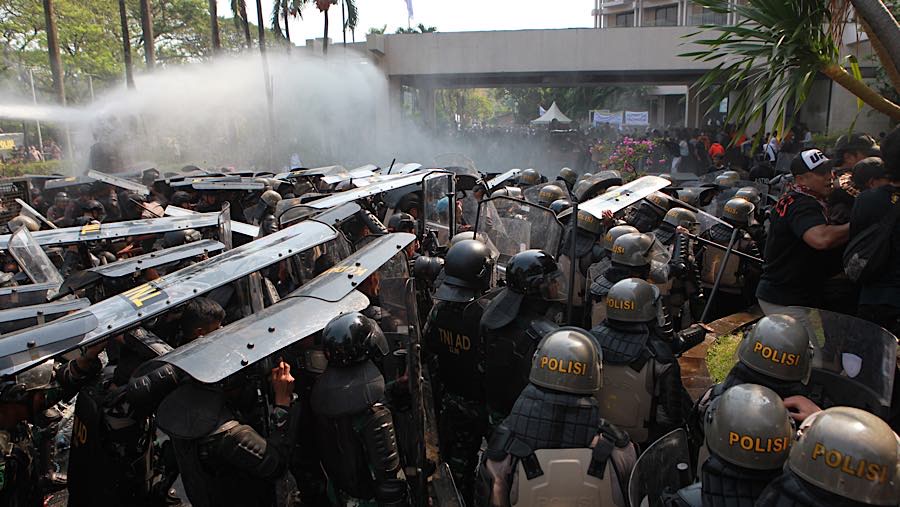 Pasukan anti huru-hara dari TNI AD dan Brimob Polri maju ke depan dan berhasil memukul mundur massa simpatisan. (Bloomberg Technoz/Andrean)