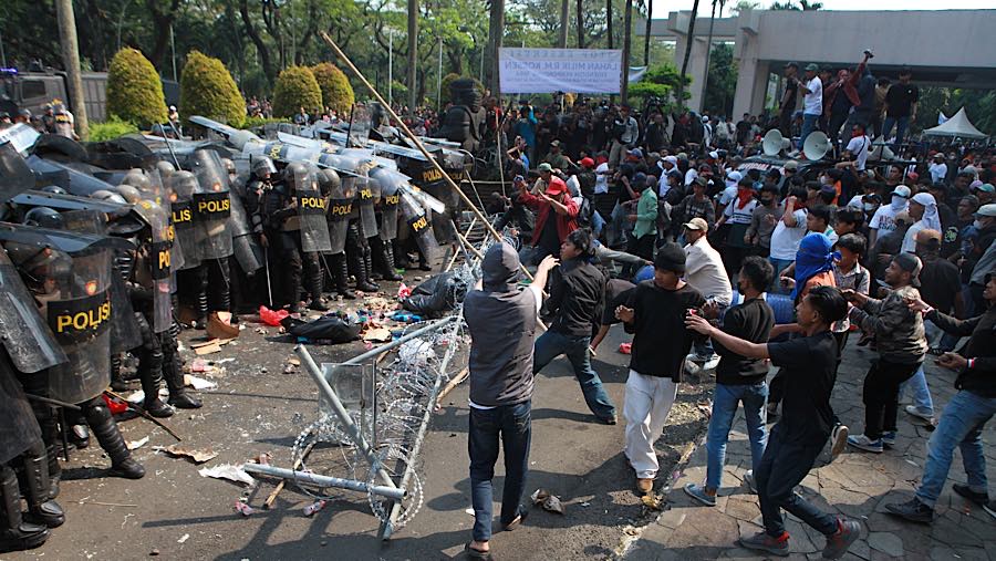 Massa mencoba menghalangi personil gabungan yang ini masuk dengan lemparan batu dan bambu.. (Bloomberg Technoz/Andrean Kristianto)