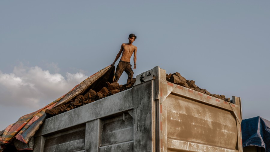 Seorang pekerja menutupi batu bara di tumpukan di lokasi tambang PT Triaryani di Musi Rawas, Sumatera Selatan, Indonesia./Bloomberg-Muhammad Fadli