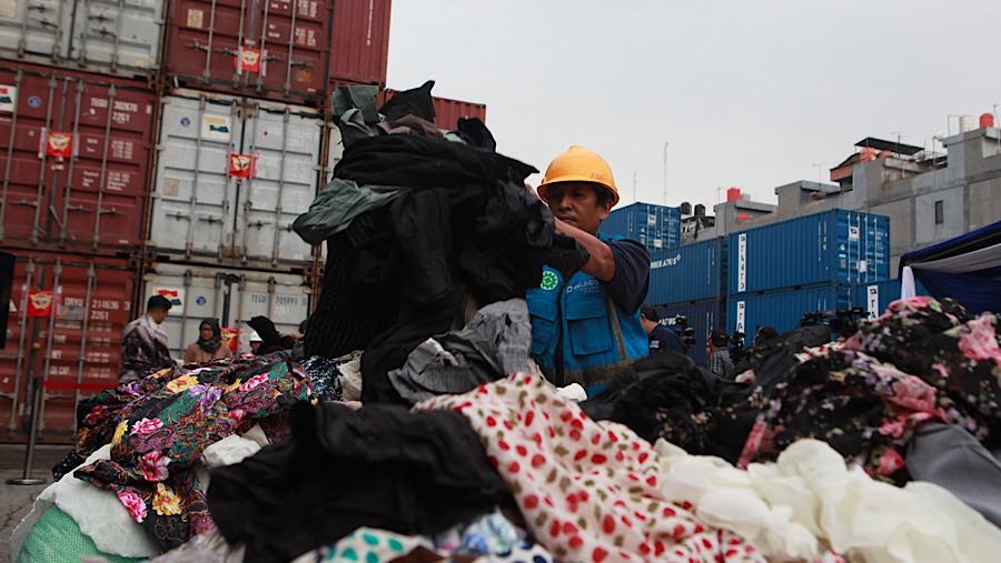 Petugas merapihkan pakaian bekas di Pelabuhan Tanjung Priok, Jakarta, Selasa, (23/6/2026). (Bloomberg Technoz/Andrean Kristianto)