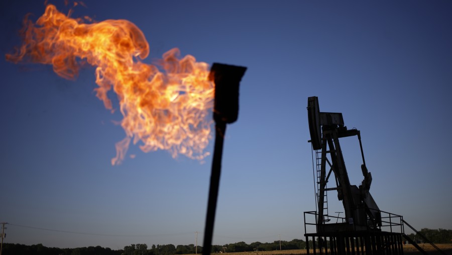 Obor gas alam menyala di dekat pompa minyak di Grayville, Illinois. (Luke Sharrett/Bloomberg)
