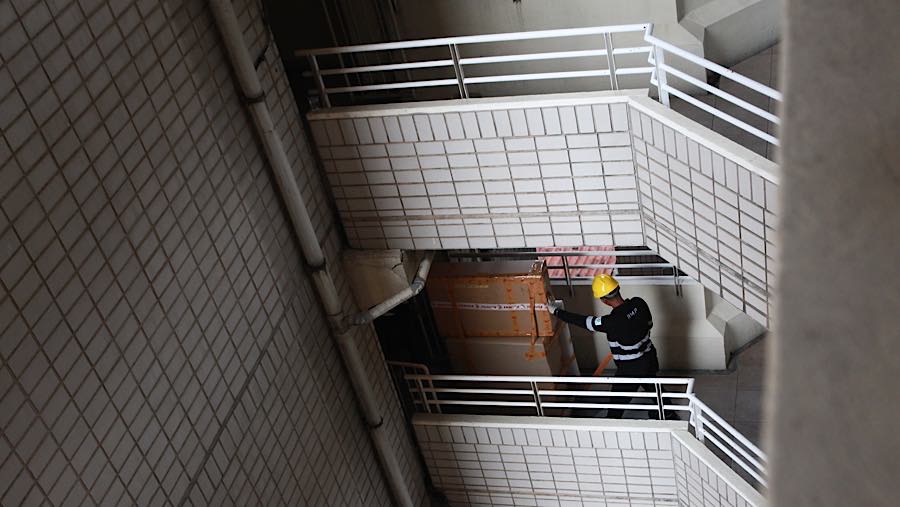 Petugas pengangkut sibuk mengemas dan mengangkut barang dari unit apartemen lantai atas ke truk logistik. (Bloomberg Technoz/Andrean K)