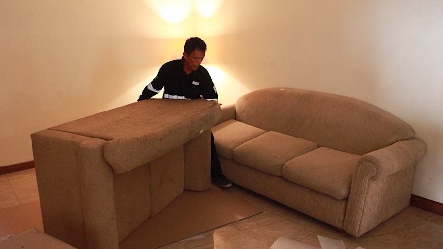 Terlihat sofa, kasur, meja, hingga lampu diangkut para petugas. (Bloomberg Technoz/Andrean Kristianto)