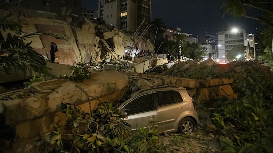 Kendaraan tertimpa puing bangunan yang runtuh di lingkungan Los Palos Grandes setelah gempa bumi di Caracas, Venezuela, Rabu (24/6/2026). (Bloomberg)