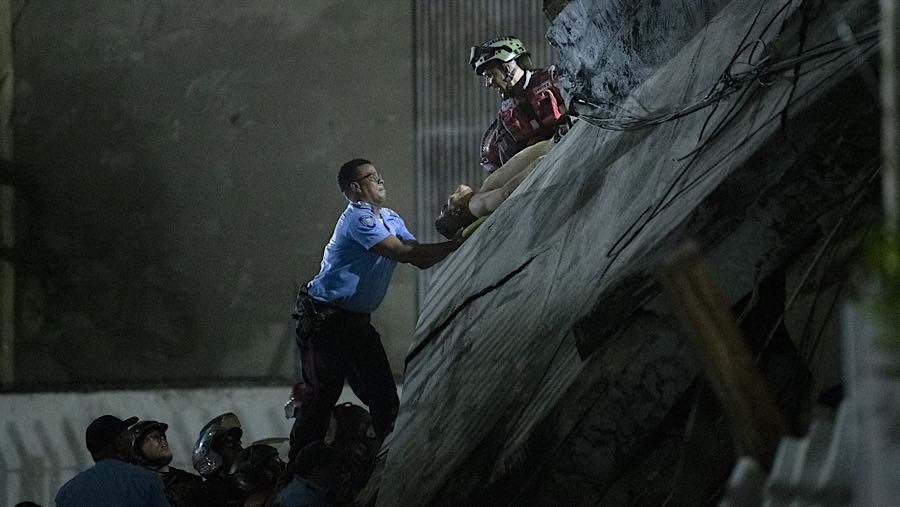 Di lingkungan Palos Grandes di Caracas timur, warga berusaha keras menyelamatkan orang-orang yang terjebak di bawah reruntuhan bangunan. (Bloomberg)