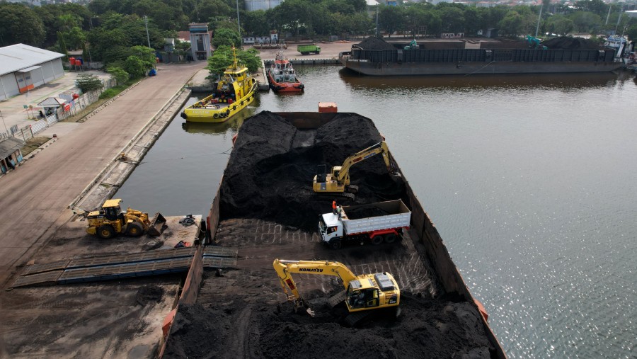 Batu bara di atas tongkang dimuat ke truk di Pelabuhan Cirebon, Jawa Barat, Indonesia./Bloomberg-Dimas Ardian
