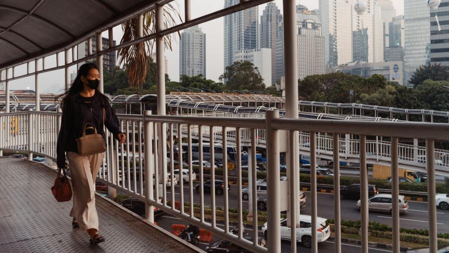 Penumpang transportasi publik Jakarta melintasi JPO. Muhammad Fadli/Bloomberg