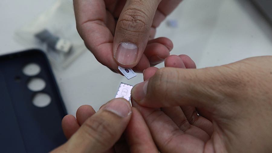 Petugas mengganti kartu sim hp pelanggan di Jakarta, Rabu (1/6/2026). (Bloomberg Technoz/Andrean Kristianto)