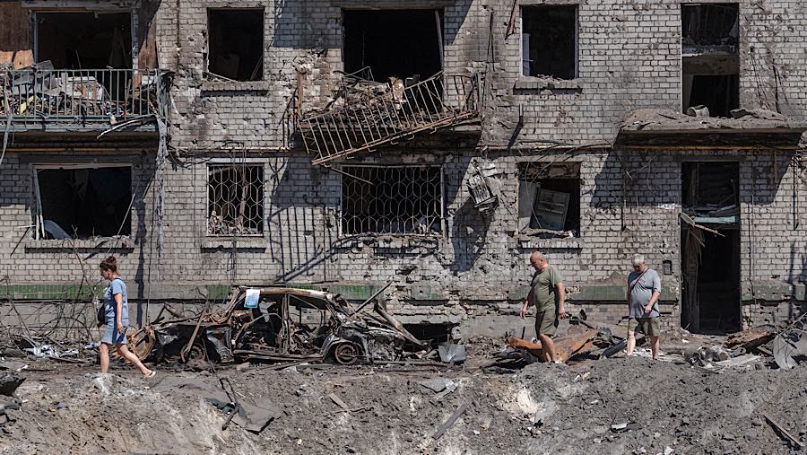 Warga berada di luar gedung apartemen yang rusak akibat serangan Rusia di Kyiv, Ukraina, Kamis (2/7/2026). (Andrew Kravchenko/Bloomberg)