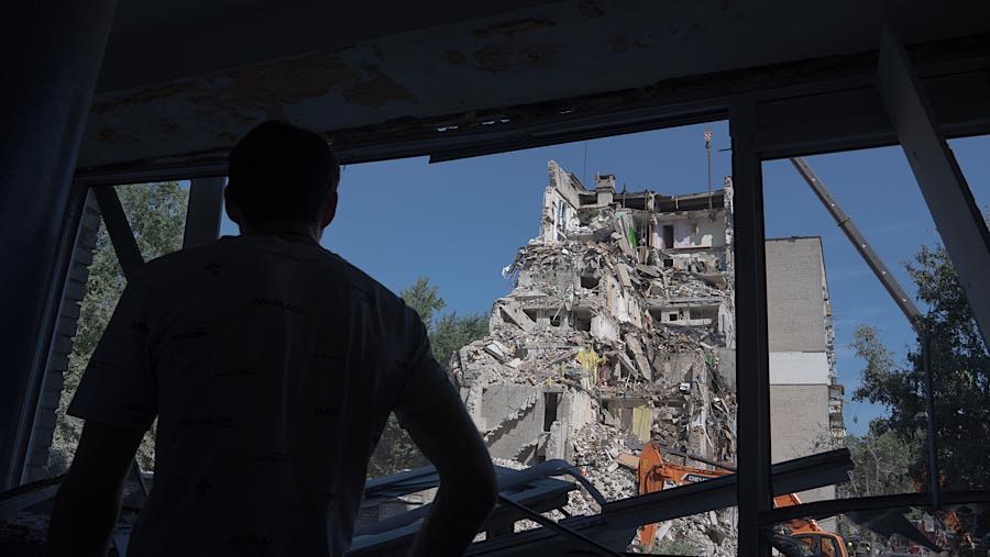 Warga melihat bangunan tempat tinggal yang sebagian runtuh setelah serangan Rusia di Kyiv, Ukraina, Kamis (2/7/2026). (Andrew Kravchenko/Bloomberg)