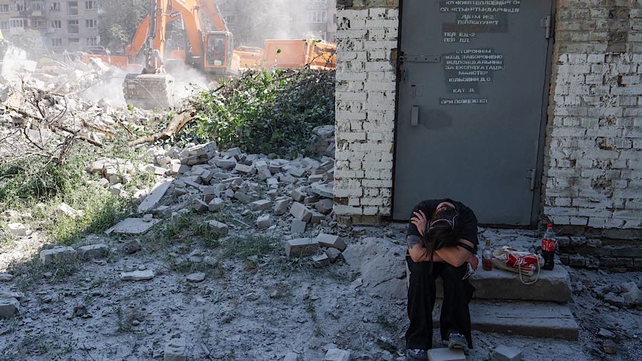 Warga duduk di tengah puing-puing setelah serangan rudal Rusia di Kyiv, Ukraina, Kamis (2/7/2026). (Andrew Kravchenko/Bloomberg)