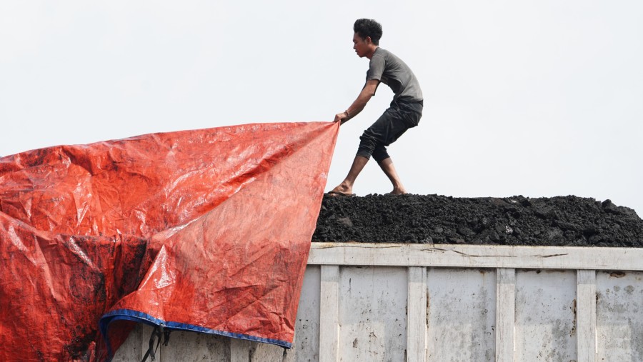 Seorang karyawan bekerja di truk berisi batu bara di Pelabuhan Marunda Karya Citra Nusantara (KCN) di Jakarta, Indonesia./Bloomberg-Dimas Ardian