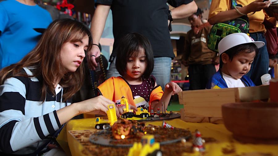 Seorang anak didampingi orang tua bermain wahana alat pertambangan di Lippo Mall Kemang, Jakarta, Jumat (3/7/2026). (Bloomberg Technoz/Andrean K)