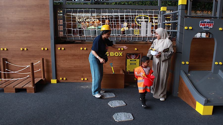 Seorang anak didampingi orang tua bermain wahana alat pertambangan di Lippo Mall Kemang, Jakarta, Jumat (3/7/2026). (Bloomberg Technoz/Andrean K)