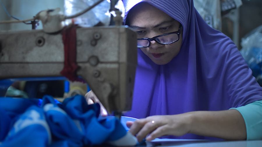 Pekerja menyelesaikan pesanan seragam sekolah di kawasan Pusat Industri Kecil, Cakung, Jakarta, Jumat (3/7/2026). (Bloomberg Technoz/Andrean Kristiant