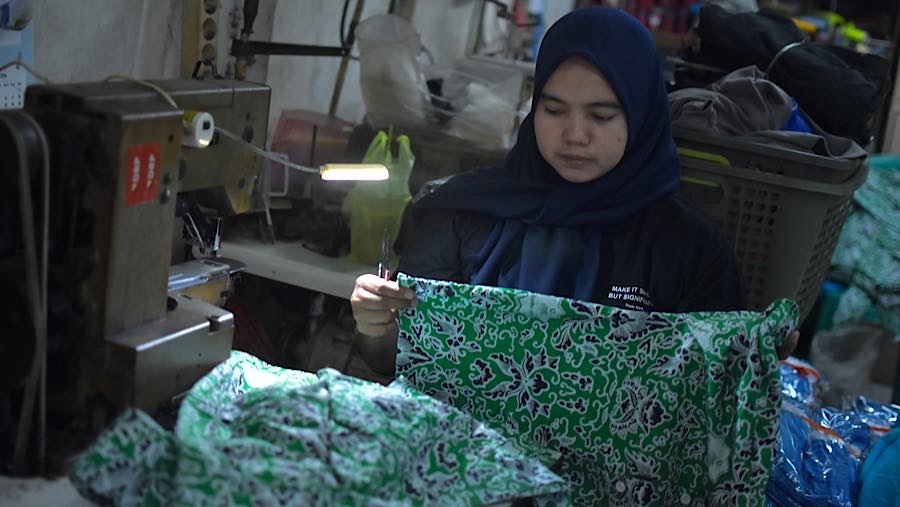 Pekerja menyelesaikan pesanan seragam sekolah di kawasan Pusat Industri Kecil, Cakung, Jakarta, Jumat (3/7/2026). (Bloomberg Technoz/Andrean Kristiant