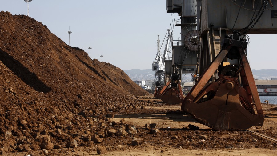 Derek pengangkut barang berdiri di samping tumpukan bijih nikel mentah di dermaga./Bloomberg-Konstantinos Tsakalidis