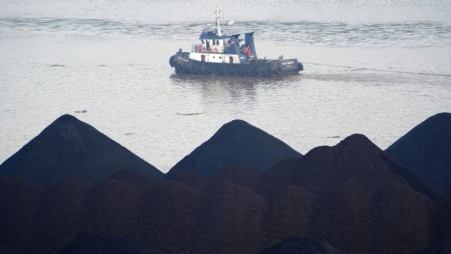 Sebuah kapal tunda berlayar melewati tumpukan batu bara di atas tongkang di Sungai Mahakam di Samarinda, Kalimantan Timur./Bloomberg-Dimas Ardian