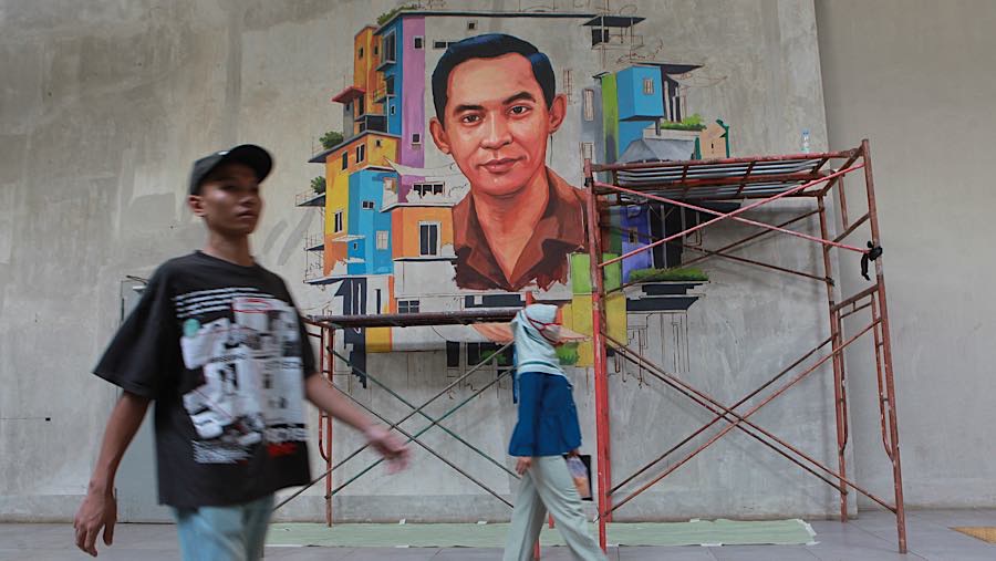 Pengunjung berjalan dengan latar mural Ali Sadikin di Taman Ismail Marzuki, Jakarta, Rabu (8/7/2026).(Bloomberg Technoz/Andrean Kristianto)