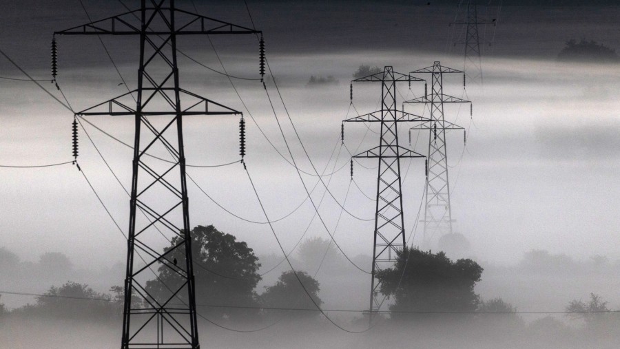 Tiang-tiang listrik diselimuti kabut pagi saat fajar. (Fotografer: Chris Ratcliffe/Bloomberg)