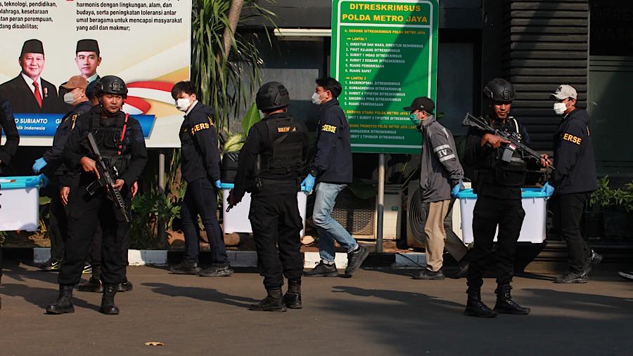 Petugas membawa barang bukti jelang konferensi pers perkembangan penyidikan di Polda Metro Jaya, Jumat (10/7/2026). (Bloomberg Technoz/Andrean K)