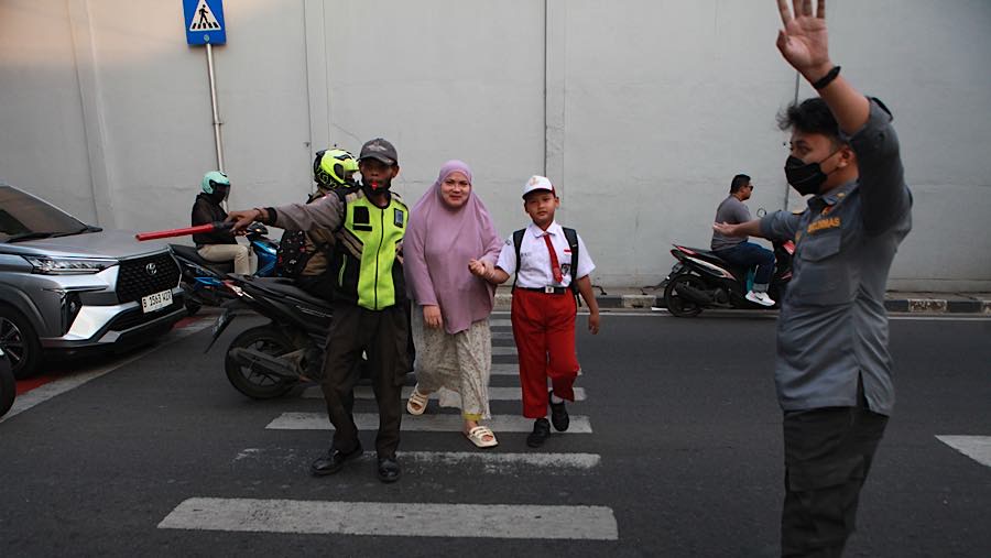 Orang tua mengantar anak saat hari pertama tahun ajaran 2026/2027 di SDN Serua 01 Ciputat, Senin (13/7/2026). (Bloomberg Technoz/Andrean Kristianto)