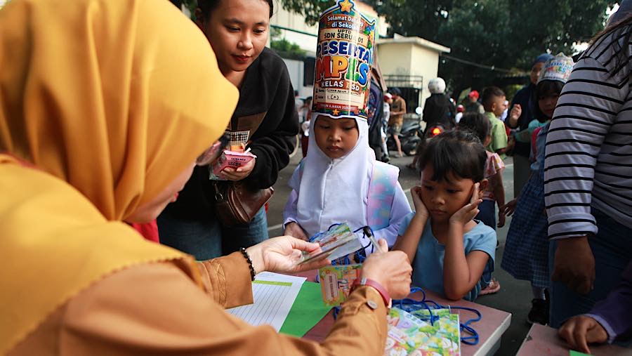 Orang tua mengantar anak saat hari pertama tahun ajaran 2026/2027 di SDN Serua 01 Ciputat, Senin (13/7/2026). (Bloomberg Technoz/Andrean Kristianto)