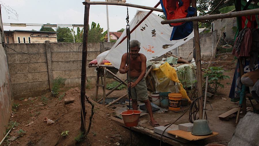 Warga berusia 52 tahun itu harus mengambil air bantuan karena sumber air di lingkungan tempat tinggalnya sulit didapat. (Bloomberg Technoz/Andrean K)