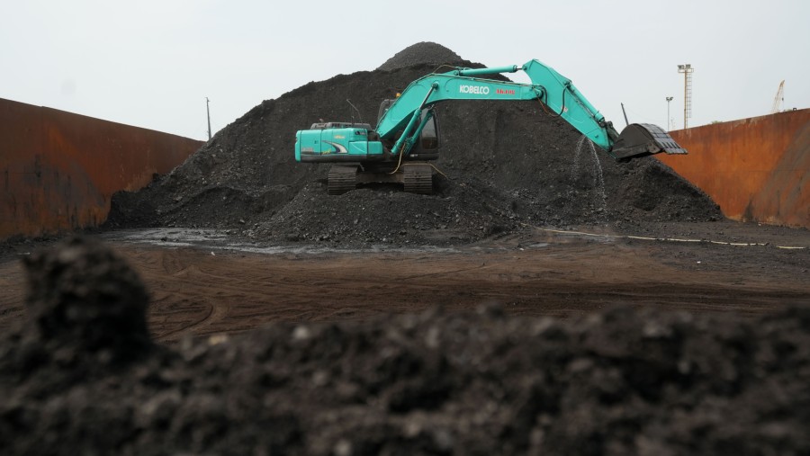 Sebuah ekskavator berada di samping tumpukan batu bara di Pelabuhan Cirebon, Jawa Barat, Indonesia./Bloomberg-Dimas Ardian