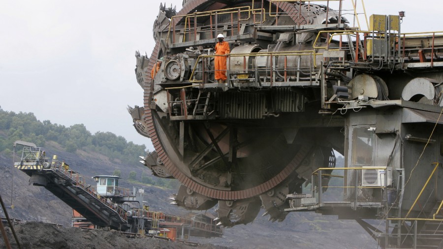 Pekerja berdiri di atas ekskavator roda ember yang sedang diperbaiki di tambang batu bara terbuka PT Bukit Asam di Tanjung Enim./Bloomberg-Dadang Tri