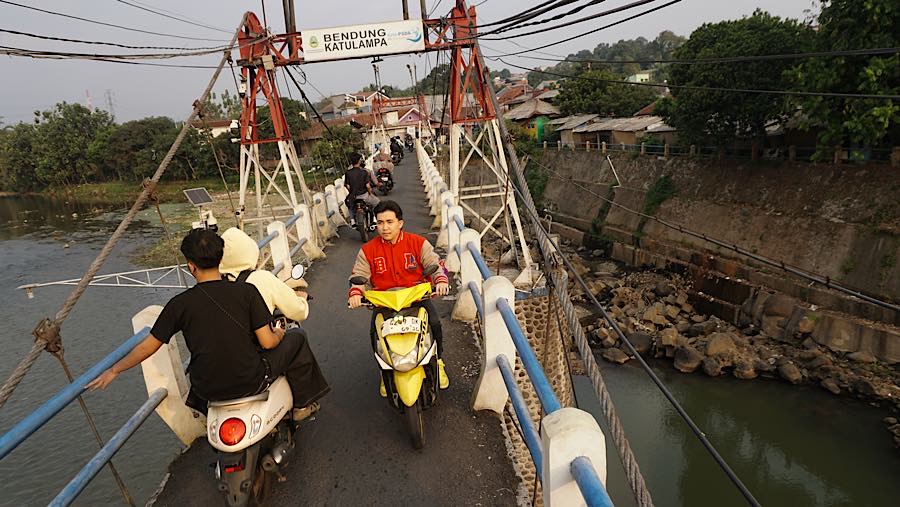 Pengendara motor melintas di jembatan Bendung Katulampa, Kota Bogor, Jawa Barat, Jumat (16/7/2026). (Bloomberg Technoz/Andrean Kristianto)