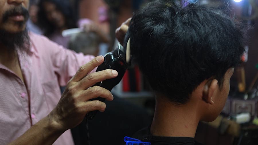 Sudah hampir empat dekade Supri menggantungkan hidup dari usaha pangkas rambut yang dirintisnya pada 1988. (Bloomberg Technoz/Andrean Kristianto)