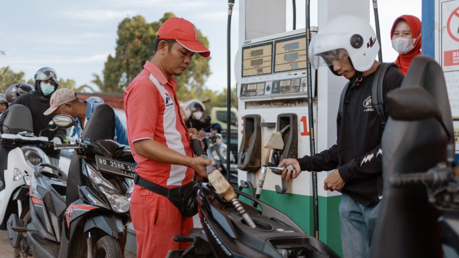Seorang pekerja mengisi bahan bakar sepeda motor di SPBU PT Pertamina di Bengkulu, Indonesia./Bloomberg-Muhammad Fadli