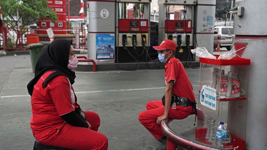 Petugas yang mengenakan masker pelindung menunggu pelanggan di SPBU Pertamina Persero PT di Jakarta, Indonesia./Bloomberg-Dimas Ardian