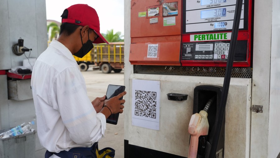 Seorang petugas memindai kode QR di SPBU PT Pertamina di Pangkal Pinang, Indonesia./Bloomberg-Dimas Ardian