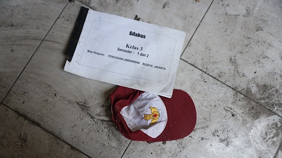 Atribut sekolah juga terlihat terbengkalai mulai dari buku dan topi yang berada di lantai sekolah.