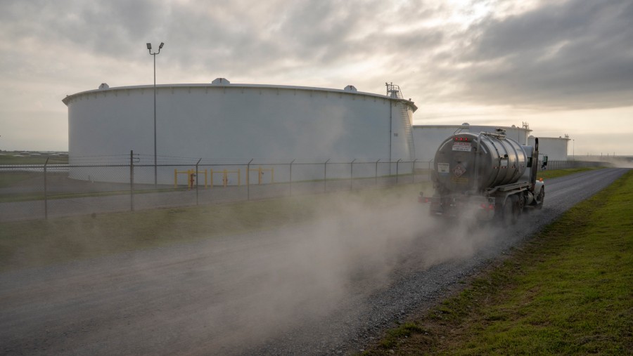 Sebuah truk pengangkut minyak melintas di dekat tangki penyimpanan minyak di terminal crude Cushing di Cushing, Oklahoma, AS./Bloomberg-Nick Oxford