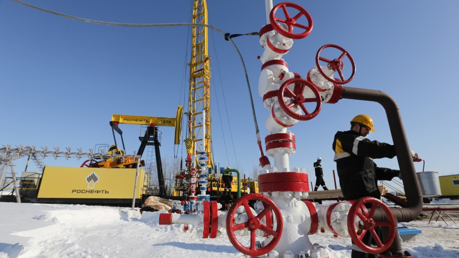 Pekerja mengambil sampel minyak mentah di anjungan sumur ganda Rosneft PJSC, di ladang minyak Samotlor, Rusia./Bloomberg-Andrey Rudakov