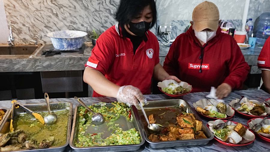 Relawan menyiapkan makanan di rumah makan gratis di jalan Raya Pekayon, Bekasi, Kamis (23/7/2026). (Bloomberg Technoz/Andrean Kristianto)