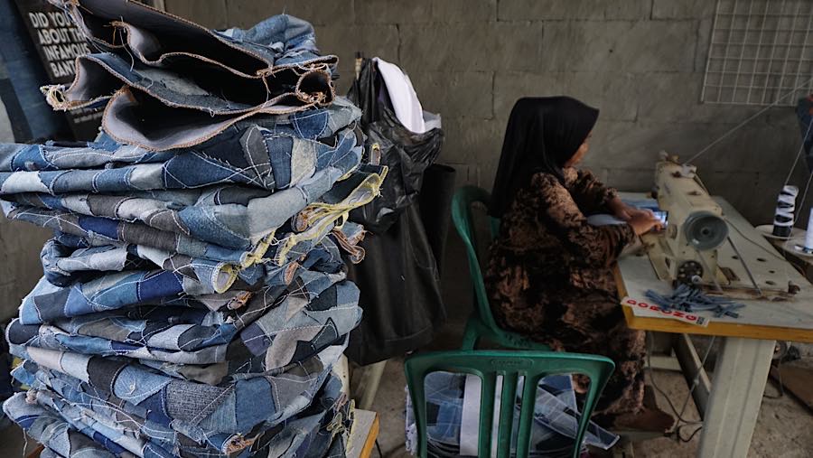 Pekerja menyelesaikan pembuatan tas dari bahan jin di Bantargebang, Bekasi, Jawa Barat, Kamis (23/7/2026). (Bloomberg Technoz/Andrean Kristianto)
