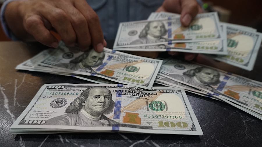 Karyawan menghitung mata uang dolar AS di tempat penukaran mata uang di Jakarta, Senin (27/7/2026). (Bloomberg Technoz/Andrean Kristianto)
