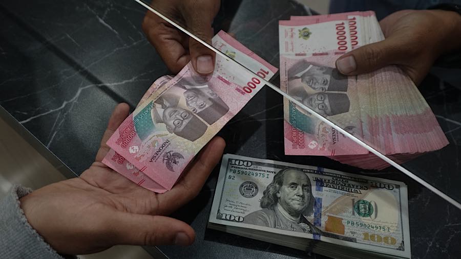 Pengunjung menukarkan mata uang dolar AS dan rupiah di tempat penukaran mata uang di Jakarta, Senin (27/7/2026) (Bloomberg Technoz/Andrean Kristianto)