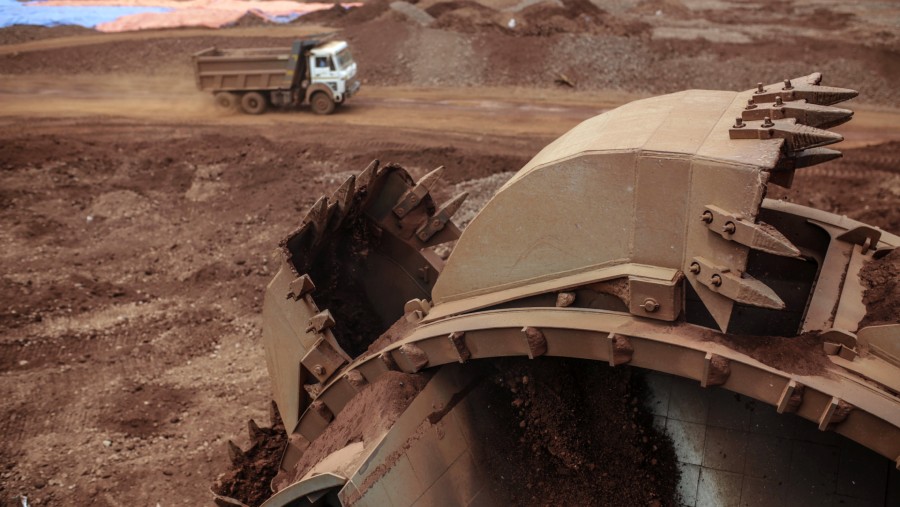 Sebuah mesin pengambil bijih bauksit beroda ember memuat bijih bauksit ke atas konveyor di Pabrik Pengolahan Alumina Vedanta Ltd./Bloomberg-Dhiraj S.