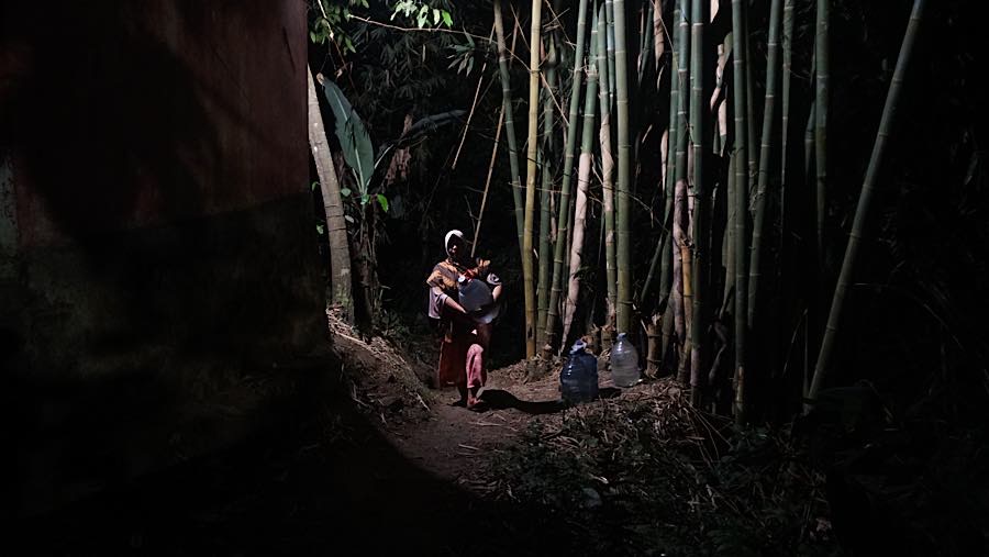 Galon berisi 15 liter air tesebut diabawa ke atas untuk menuju ke rumah mereka. (Bloomberg Technoz/Andrean Kristianto)