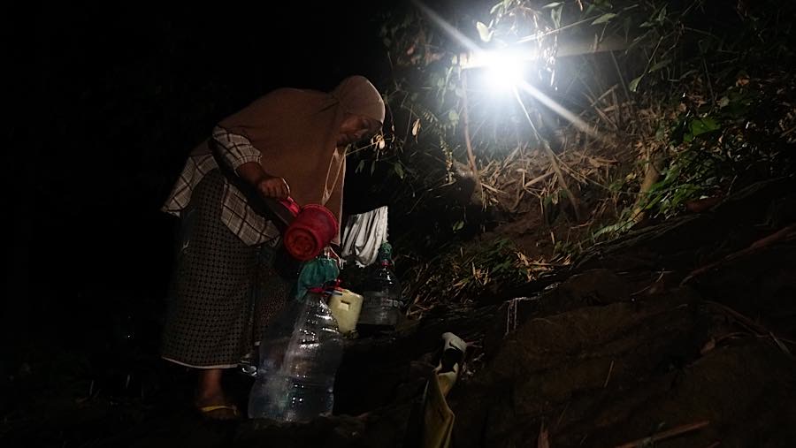 Ketika hari mulai gelap, beberapa warga mengandalkan cahaya lampu yang dipasang untuk membantu beraktivitas. (Bloomberg Technoz/Andrean Kristianto)
