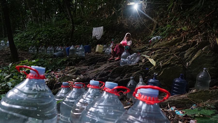 Di dasar sungai, puluhan galon berukuran 15 liter berjajar menunggu giliran terisi. (Bloomberg Technoz/Andrean Kristianto)