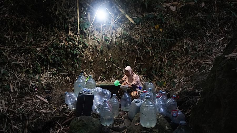 Warga mengambil air bersih di mata air Sungai Sumur Tengah, Kp. Gunung Batur 2, Cilegon, Banten (31/7/2026). (Bloomberg Technoz/Andrean Kristianto)
