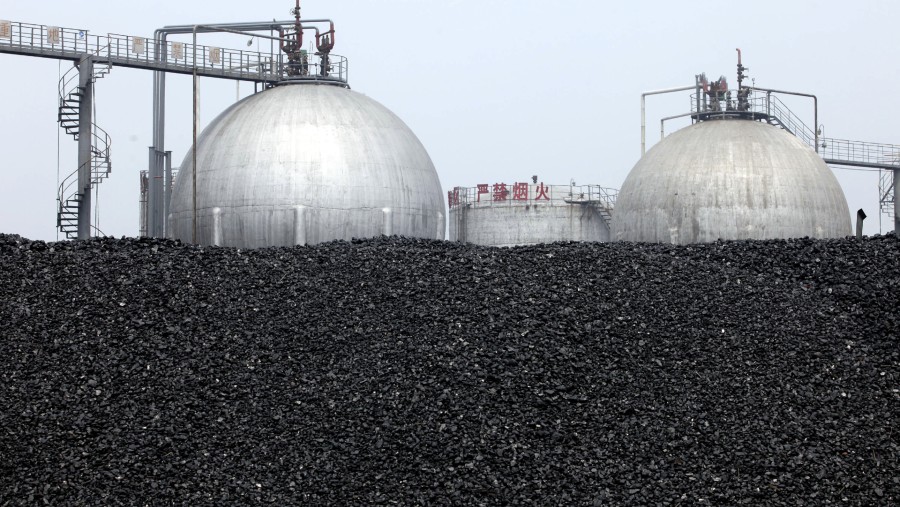 Tumpukan batu bara terlihat di dekat tangki metanol di pabrik China XLX Fertiliser Ltd. di Xinxiang, Provinsi Henan, China./Bloomberg-Doug Kanter